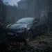 Abandoned black Renault car locked with chains and padlocks in an overgrown courtyard
